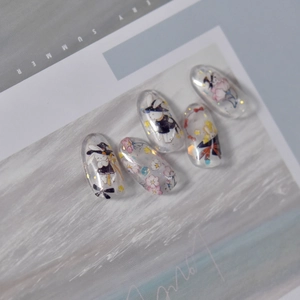 Detail of transparent nail stickers featuring hand-painted cartoon rabbits and cherry blossoms