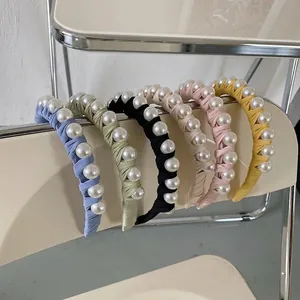 Braided fabric headbands with elegant pearl accents in various pastel colors