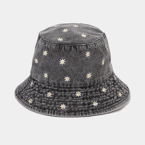 Close-up of small daisy embroidery on dark gray denim cotton fisherman bucket hat