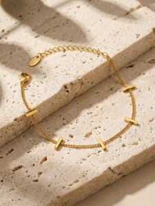 Detailed view of gold minimalist bamboo bar bracelet showing the S925 hallmark on a stone tile