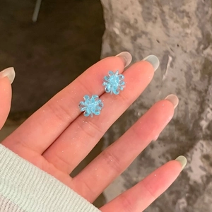 Close-up of sky blue crystal flower stud earrings with delicate petal details