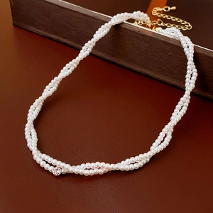 Dettaglio della collana di perle a doppio strato con diamante centrale e chiusura oro
