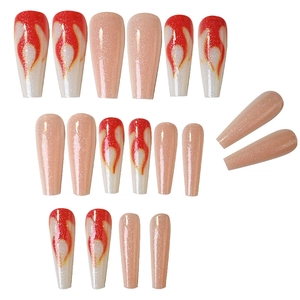 Detailed view of long pink glitter press-on nails and white nails with orange flame designs