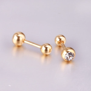 Detail of ball stud earrings with gold plating and clear zircon inlay on metal surface