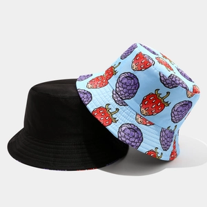 Detail of reversible bucket hats in solid black and blue fruit pattern print