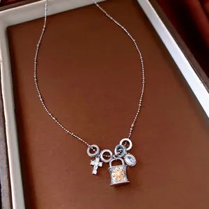 Collana con pendente a croce in zircone in vassoio di pelle marrone con vista a 45 gradi