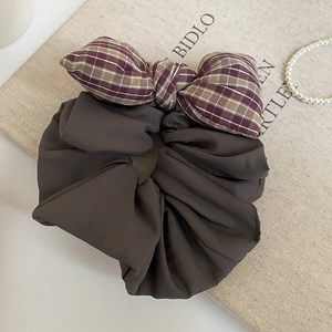 Detail of deep brown oversized mesh scrunchie with a vintage purple plaid bow accent