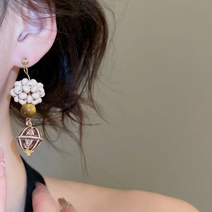 Detail view of vintage tiger eye and wooden bead earrings on model with golden hooks
