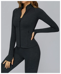 Detailed view of dark grey athletic jacket with thumb holes and full zip high collar design