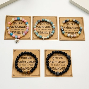 Détail macro de divers bracelets perlés avec pierres naturelles et pendentifs sur cartes