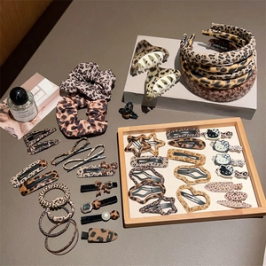 Set of leopard print hair accessories including headbands and clips on wooden tray