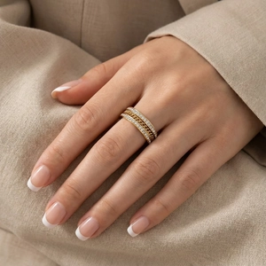 Gros plan d'une bague multicouche dorée avec cristaux latéraux et maillon cubain
