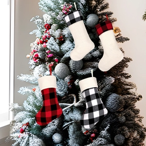 Classic red and black buffalo plaid Christmas stockings hanging on a festive tree