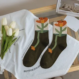 Close-up of olive green tulip socks with artistic floral knit and ruffled elastic cuff