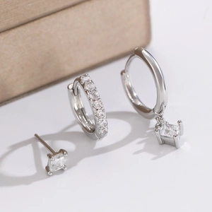 Macro shot of silver earring set with square cubic zirconia pendant and pavé hoops