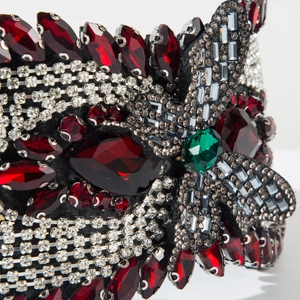 Macro shot of luxury padded headband with emerald centerpiece and red crystals