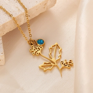 Detail of 18k gold plated leaf pendant with blue gemstone on champagne silk