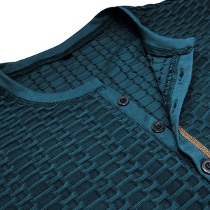 Détail du tissu gaufré bleu canard et du col Henley classique avec boutons sur le haut