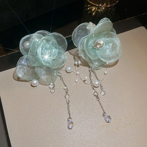 Detail of light green mesh flower earrings with silver tassels and pearls