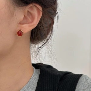Close-up of minimalist gold plated 925 sterling silver studs with red agate stones