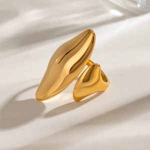 Close-up of polished golden stainless steel ring with an asymmetric liquid-metal design