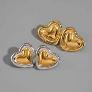 Detailed view of two pairs of heart-shaped vintage earrings in gold and silver steel finish
