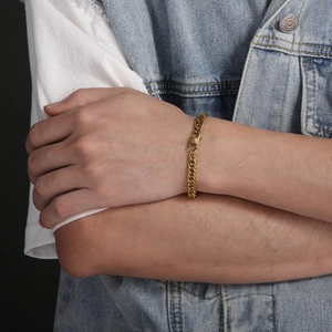 Bracelet gourmette hip hop en acier titane plaqué or 18 carats porté sur une manche
