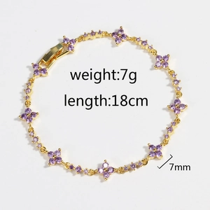 Minimalist gold bracelet with purple zircon flower clover charms on a white background