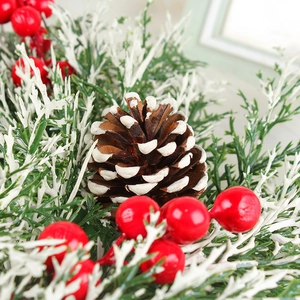 Couronne de Noël avec baies rouges pommes de pin et aiguilles enneigées pour décor de porte