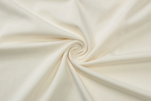 Close-up of creamy white ribbed knit fabric texture with soft spiral folds