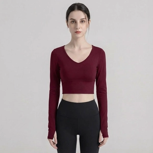 Detail view of burgundy slim fit yoga top featuring V-neck and thumbhole cuffs design