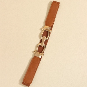 Detail of caramel brown elastic belt with elegant interlocking gold metal buckles