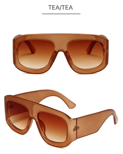 Detail of square tea-colored sunglasses with oversized frames and gradient lenses