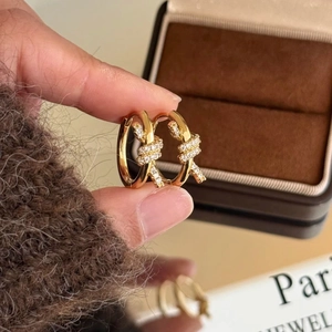 Gros plan de boucles d'oreilles nouées plaquées or avec zircons sur un coffret