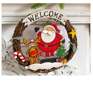 Detail of Christmas wreath with wooden Santa, reindeer, and Welcome sign on white mantel