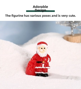 Miniature resin Santa Claus figurine holding a red gift bag in a snowy holiday scenery