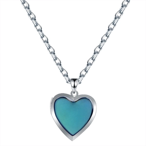 Macro view of heart-shaped locket pendant with blue-green temperature color change stone