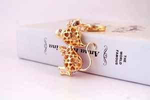 Detailed macro view of a golden hollow mouse keychain with sparkling pink rhinestones