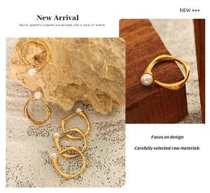 Detail of adjustable gold-plated titanium ring with pearl on a wooden base