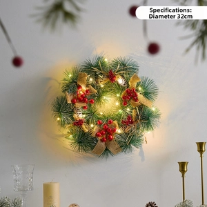 Detailed view of a Christmas wreath with glowing LED lights and red berry accents