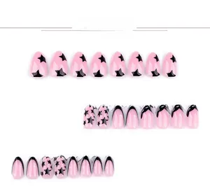 Detail of short almond press-on nails featuring black star patterns and French tips