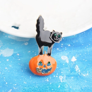 Detail of Halloween black cat on pumpkin brooch with green rhinestones and gold plating