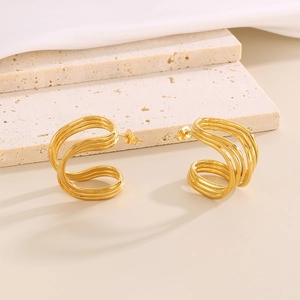 Detail of C-shaped gold-plated stainless steel earrings with textured grid pattern