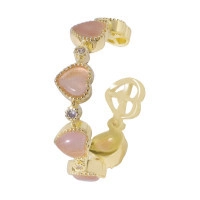 Golden heart earrings with pink cat eye stones and small zircons on a white background