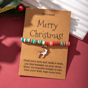Close-up of Christmas polymer clay bead bracelet featuring a white enamel reindeer charm