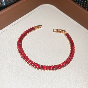 Close-up of elegant 18k gold-plated ruby bracelet with a secure snap clasp in a luxury box