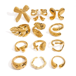 Set of 12 gold stainless steel rings with pearl and gemstone charms on white background