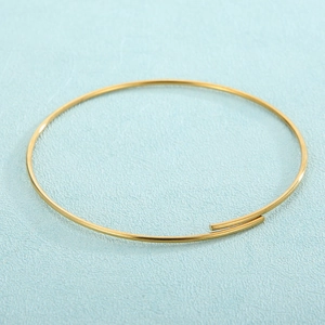 Minimalist gold plated stainless steel open bangle bracelet for DIY jewelry on blue surface