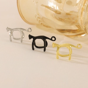 Detailed close-up of abstract cat-shaped ear cuffs in silver, black, and gold metal