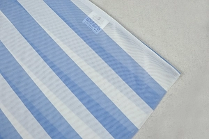 Detailaufnahme von blau-weiß gestreiftem Mesh-Gewebe mit Größenetikett S und Pflegehinweis